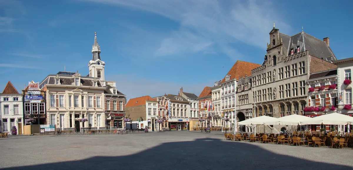 Breed panorama van de Grote Markt in Bergen op Zoom met historische panden en terrassen.