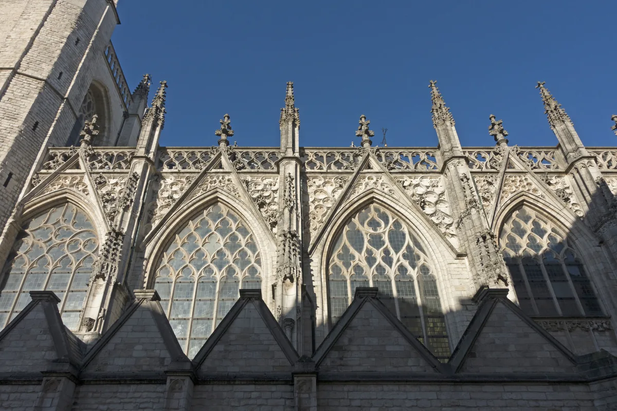 Gotische buitengevel van de Grote Kerk in Breda tegen een blauwe lucht.