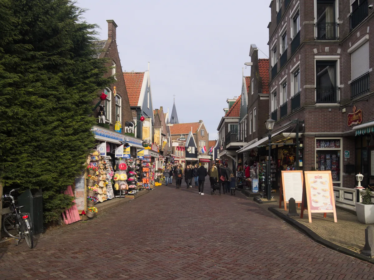 Drukke Havenstraat in Volendam met traditionele gevels, winkels en bezoekers.